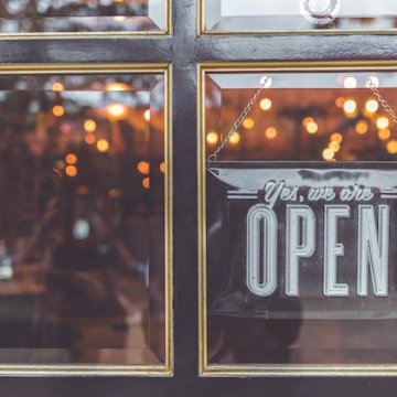 store front with open sign hanging in a window